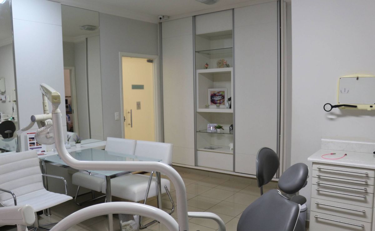 Consultório odontológico com cadeira e armários